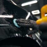 Auto detailing professional preparing automobile for polishing