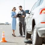 Worker with woman near the broken car on the highway